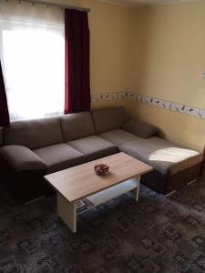 a living room with a couch and a coffee table at Százszorszép Vendégház in Mezőkövesd