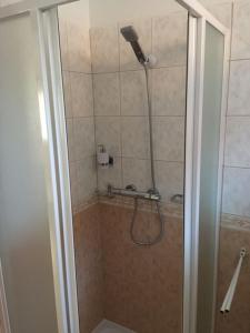 a shower with a shower head in a bathroom at Százszorszép Vendégház in Mezőkövesd