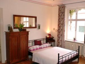 Schlafzimmer mit einem Bett und einem Wandspiegel in der Unterkunft Anno-Nostalgia in Rheinsberg