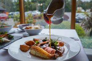 a plate of food with sauce being poured on it at Draycote Hotel And Whitefields Golf Course in Rugby