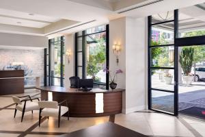 an office lobby with a desk and chairs and large windows at Victoria Marriott Inner Harbour in Victoria