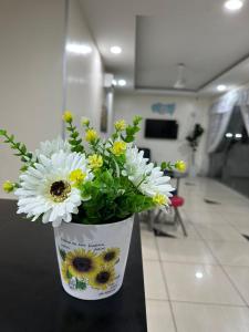 a vase filled with flowers sitting on a table at ISLAND TIME MOTEL KUAH in Kuah