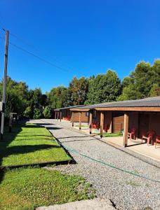 ein Gebäude mit einer Linie roter Stühle davor in der Unterkunft Hosteria y Cabañas Rucantu in Freire