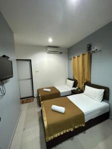 een kamer met 2 bedden en een flatscreen-tv bij ISLAND TIME MOTEL KUAH in Kuah