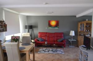 uma sala de estar com um sofá vermelho e uma televisão em Ferienhaus Stana em Leer