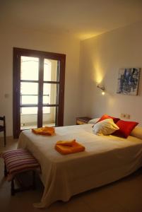 a bedroom with a large bed with orange towels on it at Na Margarida in S'Illot