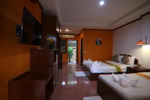 Habitación de hotel con 2 camas y TV de pantalla plana. en Coconut House Resort en Koh Samui