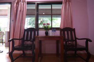 una mesa con dos sillas y un jarrón de flores. en Coconut House Resort en Koh Samui