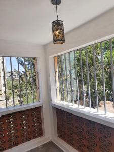 a room with two windows and a pendant light at Stellar 1-bedroom apartment in Madaraka Estate, Nairobi in Nairobi