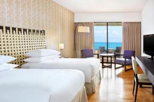a hotel room with two beds and a dining area at Sheraton Rhodes Resort in Ixia