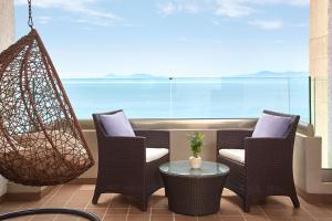 a patio with chairs and a table and a large window at Sheraton Rhodes Resort in Ixia