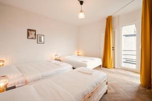 une chambre avec trois lits et une fenêtre dans l'établissement Charming and Spacious Antwerp City Center Apartments, à Anvers