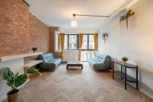 - un salon avec deux chaises bleues et un mur en briques dans l'établissement Charming and Spacious Antwerp City Center Apartments, à Anvers