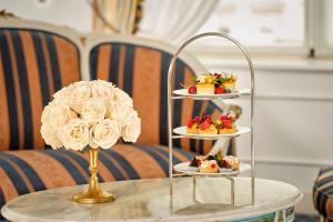 a table with three tiers of desserts on a table with a flower at Hotel Imperial, a Luxury Collection Hotel, Vienna in Vienna
