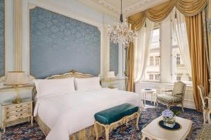 a bedroom with a large white bed and a chandelier at Hotel Imperial, a Luxury Collection Hotel, Vienna in Vienna