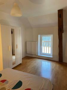 um quarto vazio com uma cama e uma janela em Gite Le Baulois, maisonnette calme et confort en vallée de Loire em Baule