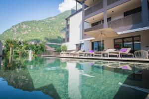 una piscina con sillas y una sombrilla junto a un edificio en Residence Sonja - Apartment Pinus, en Rablà