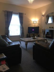 uma sala de estar com um sofá e uma mesa de centro em Silverhill House Apartment em Enniskillen