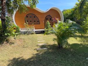 una pequeña casa con una valla en el patio en ANGEL RESORT i, en Amphoe Sawang Daen Din