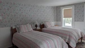 sypialnia z 2 łóżkami i oknem w obiekcie Blue Bear inn w mieście Francestown