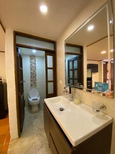 a bathroom with a sink and a toilet and a mirror at Hotel Casona del Virrey in Moniquirá