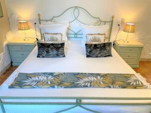 a bedroom with a large white bed with two lamps at Hôtel Le Méditerranée in Hyères