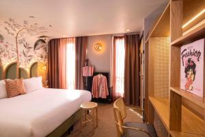 巴黎Hôtel Jardin de Cluny的配有一张大床和一把椅子的酒店房间