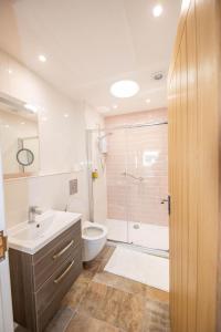 a bathroom with a sink and a toilet and a shower at Gardener's Cottage in Alnwick