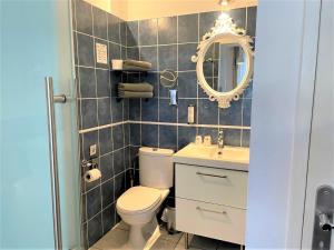 a bathroom with a toilet and a sink and a mirror at Hôtel Le Méditerranée in Hyères