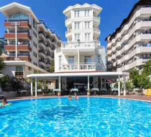 a large swimming pool in front of a building at Azak Hotel in Alanya