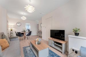 a living room with a couch and a flat screen tv at Comfort Zone in Yiewsley