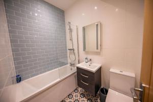 a bathroom with a tub and a sink and a toilet at The Kennelman 2 bedroom option in Alnwick
