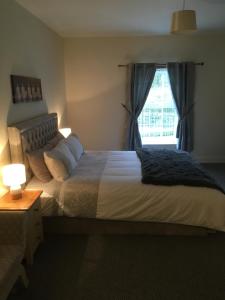 um quarto com uma cama grande e uma janela em Silverhill House Apartment em Enniskillen