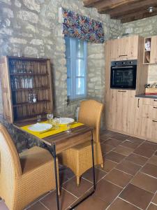 a kitchen with a table and chairs in a room at A l’ombre du Tilleul in Crestet