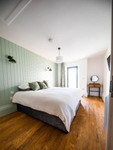 a bedroom with a large bed and a wooden floor at The Coach House in Alnwick