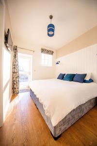 um quarto com uma grande cama branca com almofadas azuis em The Kennelman 3 bedroom option em Alnwick