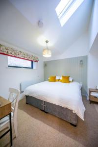 um quarto com uma cama grande e almofadas amarelas em The Kennelman 3 bedroom option em Alnwick