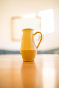 um jarro amarelo sentado em cima de uma mesa de madeira em The Kennelman 3 bedroom option em Alnwick