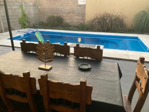 una mesa con sillas y una piña junto a una piscina en Mandela en Paraná