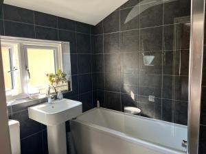 a bathroom with a white tub and a sink and a toilet at Isabella's Yard in Stamford