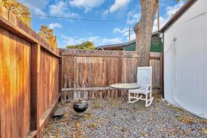 a table and a chair in front of a fence at A Cottage - Walk to UC Davis & Shriners in Sacramento