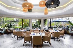 un restaurante con mesas, sillas y ventanas grandes en Long Beach Marriott, en Long Beach