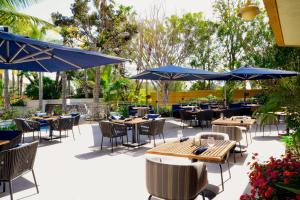 a patio with tables and chairs and umbrellas at Long Beach Marriott in Long Beach