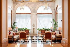 a lobby with chairs and tables and windows at Hotel Grande Bretagne, a Luxury Collection Hotel, Athens in Athens