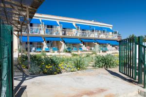 un edificio con toldos azules y una valla en Le Surplage, en Hyères