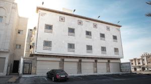 a building with a car parked in front of it at Comfortable & Big Family Apartments 10Mins Drive to Al-Masjid -Nabawi in Al Madinah