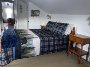 a bedroom with a bed and a table with a night stand at Blue Bear inn in Francestown