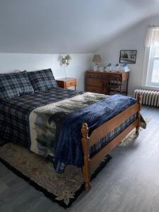 um quarto com uma cama com um cobertor azul em Blue Bear inn em Francestown