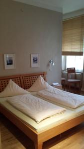 sypialnia z dużym łóżkiem z białą pościelą w obiekcie Hotel Restaurant Frankenturm w Trewirze