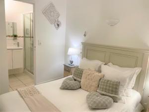 a white bed with pillows on it in a bedroom at Hôtel Le Méditerranée in Hyères